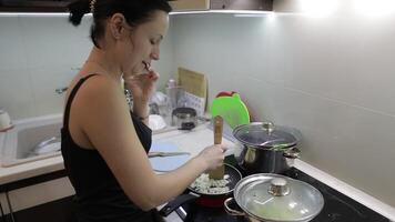 Beautiful caucasian woman talking on the phone while cooking video