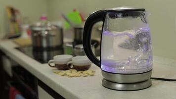 thee waterkoker met koken water. thee Tassen en suiker Aan de achtergrond video