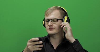 Guy listens to music in wireless yellow headphones and dances. Chroma key video