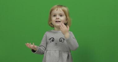 niño niña en un verde pantalla, croma llave. contento Tres años antiguo niña video