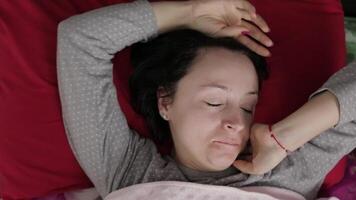 Sleepy young woman does not want to wake up in the morning. Top view video