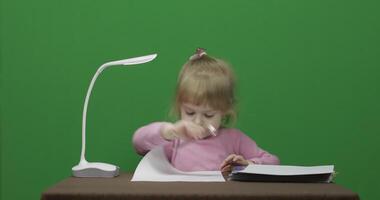 niña dibujo a el mesa. educación proceso. Tres años antiguo niño. croma llave video