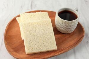 Plain White Bread with Black Coffee in Wooden Tray photo