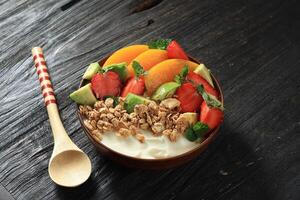 Yogurt Bowl with Fresh Berries, Granola, Avocado,  and Peach photo