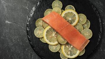Fresh Salmon Fillet on Lemon Slice on Marble Table photo