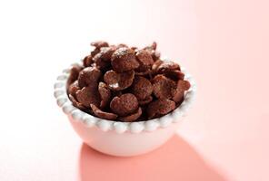 Chocolate Cereals in White Bowl. Chocolate Flavored Corn Flakes. photo