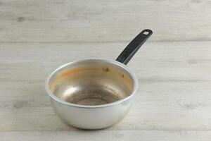 Old Used Stock Noodle Sauce Pan on White Wooden Table photo