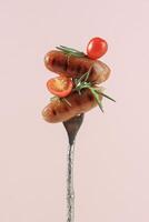 Grilled Sausages with Rosemary and Cherry Tomato on Silver Fork photo