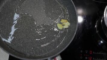 frito fatiado alho e ebulição Comida óleo dentro a Preto panela video