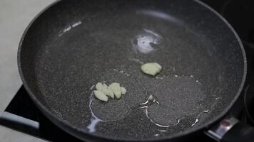 Fried sliced garlic and boiling food oil in the black pan video