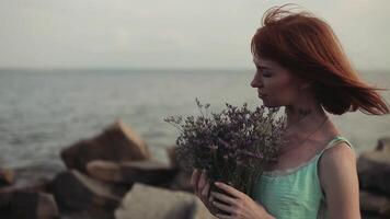 lento movimento. un' bellissimo giovane sexy ragazza con lungo rosso capelli nel un' turchese vestito ha un' romantico umore video