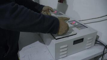 Italy, Rome - August 10, 2022. Close-up of worker installing battery in machine. Creative. Battery in machine of industrial plant. Installation of battery for shuttle racks in warehouse photo