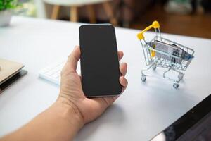 joven mujer es compras en línea mediante móvil solicitud por pago con su crédito tarjeta conveniencia de pago mediante compras en línea. concepto de en línea compras y gasto mediante crédito tarjeta. foto