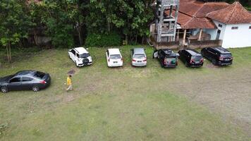 Aerial photo of a line of cars in a field in Mindi, Klaten, Central Java, Indonesia.