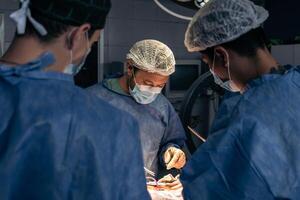 equipo de doctores en un operando habitación foto