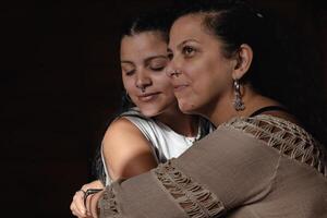 Portrait of middle-aged Latina mother with young adult daughter. photo