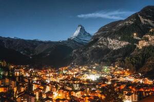 Zermatt village with light glowing and Matterhorn peak in the night at Switzerland photo