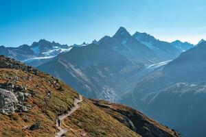 Woman with backpack hiking with Mont Blanc massif in French Alps on trail of Lac Blanc at France photo