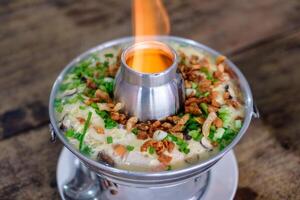 Steamed Egg Kai thoon with eggs, pork, meat and vegetables in pot with fire photo