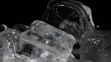 Ice cubes melting rotating on black background video