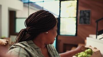 POV of vendor promoting organic products on camera, recording social media ad video of her zero waste eco store in the neighborhood. African american woman presenting bio merchandise. Handheld shot.