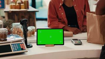 tableta corriendo monitor con blanco pantalla verde a verificar, demostración aislado chromakey diseño en local tienda de comestibles almacenar. comerciante teniendo dispositivo con copyspace Bosquejo disposición, no contaminante pequeño negocio. video