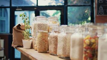 Local zero waste grocery store with bulk products in jars, empty supermarket isles. Additives free pasta, sauces and spices stored in recyclable glass containers on display. Handheld shot. video