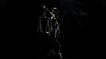 Lady justice in rotation over black background with strands of smoke video
