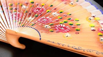 Decorated hand fan in rotation video