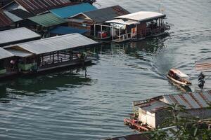 Traditional wooden raft floating with long-tail boat on river at Sangkhlaburi photo