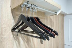 Clothes hangers empty on rail in closet photo