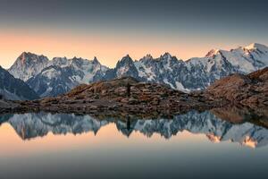 Lac Blanc with Mont Blanc mountain range and male tourist reflect on the lake in French Alps at Chamonix, France photo