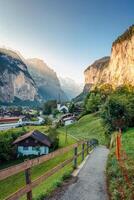 Lauterbrunnen valley with rustic village, famous church and waterfall during summer in the morning at Switzerland photo