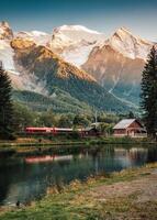 Lac des Gaillands with Mont Blanc massif and train at station in the sunset at Chamonix photo