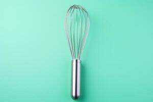 AI generated Metal whisk on color background, top view photo