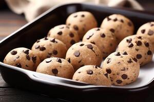 AI generated Baking pan with raw chocolate chip cookie balls on table, closeup photo