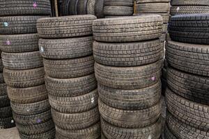 AI generated stacks of used good condition tires for cars, close full-frame background photo