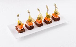 canapes with cheese and red fish photo