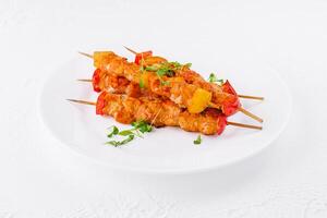 Chicken skewers with slices of sweet peppers photo