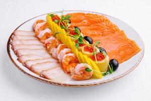 salmon, white fish, shrimp and red caviar on plate photo