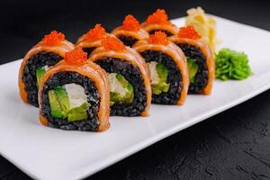 Black rice sushi rolls with salmon on white plate photo