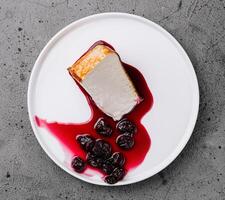 Cheesecake with berry sauce on plate photo