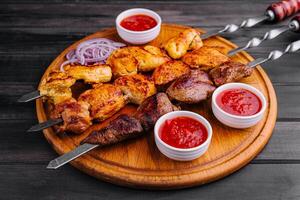Metal skewers with delicious meat and ketchup sauce photo
