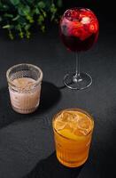 Glasses of cold infused water with fresh orange and strawberry slices and iced coffee photo