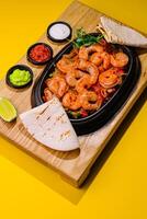 Fried large shrimp with onions and peppers in a frying pan photo