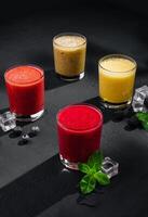 Strawberry, raspberry and banana smoothies on stone photo