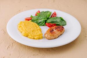 polenta with cutlet and cherry tomatoes with basil photo