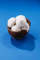 Coconuts with candies on blue background photo