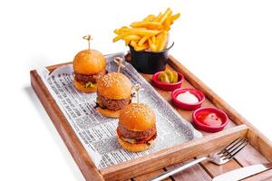 mini burgers with fries on wooden tray photo