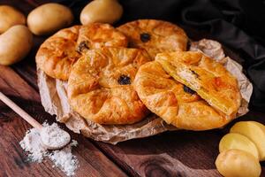 Cocinando tradicional pasteles con patatas en de madera mesa foto